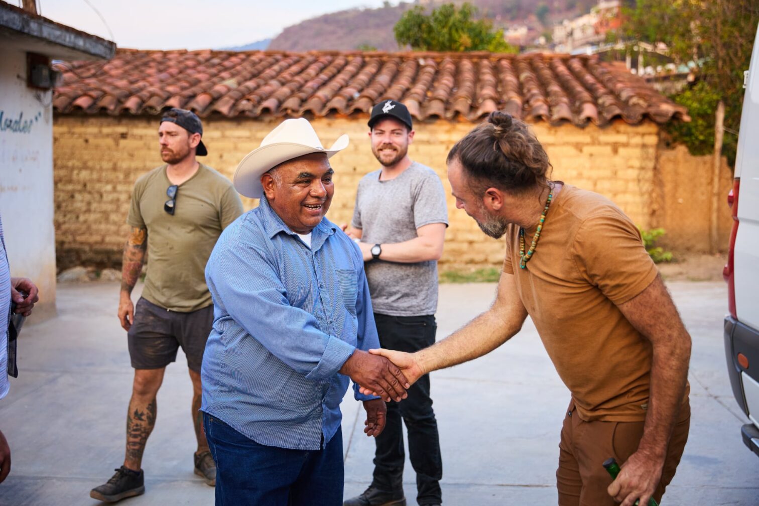 Image of people working on Del Maguey shaking hands