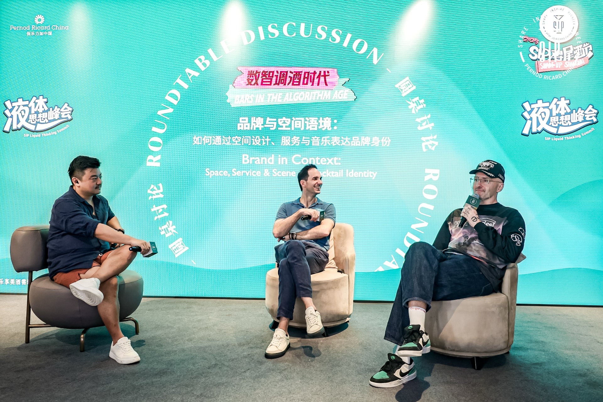 Three people on stage during an online masterclass